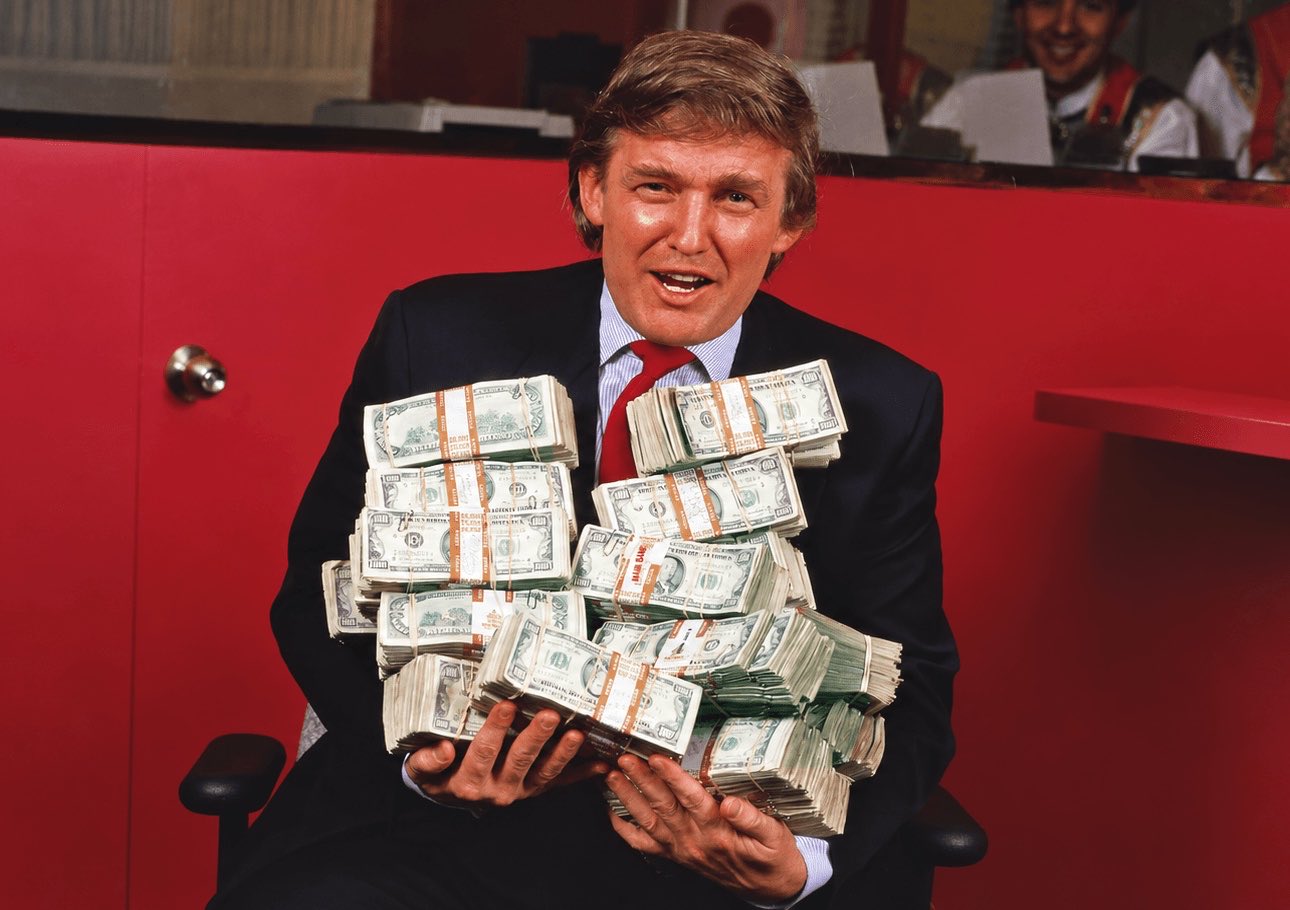 This image does not contain a crypto chart. It shows a person in a suit holding 